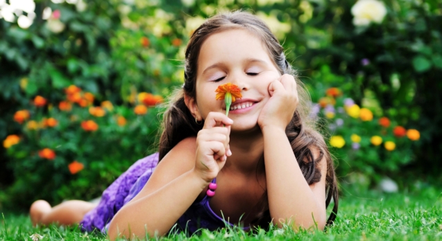 happy young girl children relax lie and have fun on grass with flower