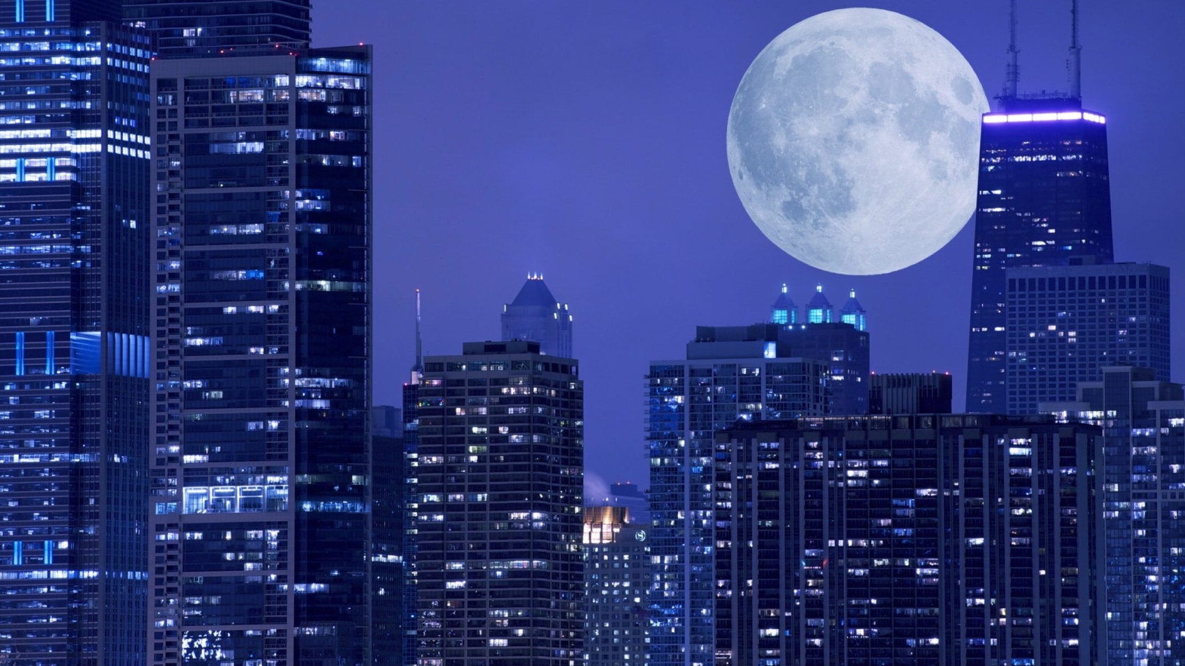 Skyline and Large Moon on the Horizon. Downtown Chicago with Hancock Tower on the Right Side. Panoramic Chicago Skyline.